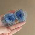 Gros plan de boucles d'oreilles fleurs en tissu bleu avec pétales en organza multicouches - Style Fleur en Tissu Dégradé Bleu