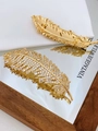 Golden feather brooch with shimmering zircon stones shown on a reflective surface - Gold White Zircon