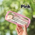 Pink transparent PVC pencil case with stationery inside held against a natural background - Pink