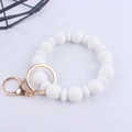 Dettaglio del braccialetto in perle di silicone bianco con anello dorato e moschettone - Bianco