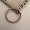 Detail of khaki high-elastic hair tie with decorative gold-tone metal bead on white surface - Beige