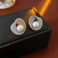 Detailed close-up of a white pearl stud earring with spiral zircon accents on black leather - White Pearl Spiral Style (1#银针-银色)