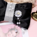 Close-up of black satin handbag with rhinestone handle and pearl daisy pendant - Silver Flower Style