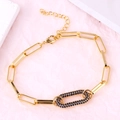 Gold paperclip chain bracelet with a blue stone oval link on a soft pink background - Oval Blue Zirconia Bracelet