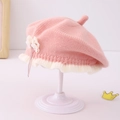 Dettaglio del berretto in maglia per neonata con texture rosa, balza bianca e fiocco - 1-3 Anni / Rosa