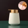 Speckled beige ceramic soap dispenser with matte gold pump head and liquid demo detail - Rounded / Off-white with Gold Pump