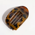 Detail view of a leopard print acetate claw clip with a sleek oval-shaped hollow design - Leopard Orange Yellow