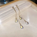 Detail view of gold drop tassel earrings with iridescent crystal charms on beige tray - Gold Aurora Teardrop (51# Silver Earring Post)