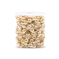 Macro detail of white daisy flower beads on a golden chain spool for DIY jewelry - White
