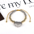 Adjustable cord bracelet with silver matte heart pendant and gold metal beads on white background - Silver