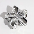 Macro detail of silver metal lily hair claw with polished mirror finish and teeth - Silver