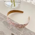Chic pink floral pattern fabric headband with brown inner lining on a white desk - Pink Floral
