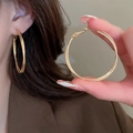 Minimalist textured oval hoop earrings in golden finish shown on model ear - 45mm Gold Large Hoop Textured Style (83#)