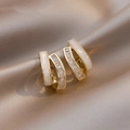 Close-up of gold-plated intertwined earrings with pearl petals and zircon crystals - Exquisite Grand Earrings - E4273 Gold