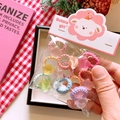 Dettaglio di elastici per capelli bambini con perle a stella su sfondo a quadretti - Elastico a Stella
