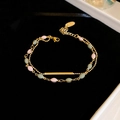 Detalle de una pulsera de doble capa bañada en oro con cuentas rosas y verdes en terciopelo - Pulsera De Doble Capa Geométrica Rosa