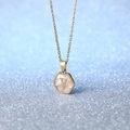 Gold hexagon necklace with V initial and white shell inlay on blue glitter background - Letter V