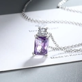 Macro shot of silver necklace with rectangular purple gemstone and white zircon pendant - Purple Zirconia