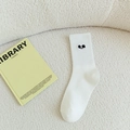 White crew socks with cute black embroidery on a soft minimalist background - White (Black Eye)