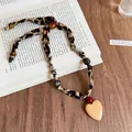 Dettaglio della collana in tessuto vintage con stampa leopardata, perle in legno e cuore - 14# Collana-Caffè