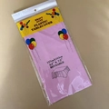 Close-up of pink disposable PE plastic tablecloth 137x183cm in original packaging - 54x72 Inch / Pink