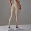 Detail of high-waist yoga pants featuring honeycomb texture and seamless peach lift fabric - Beige