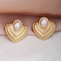 Détail macro de boucles d'oreilles vintage dorées avec perle blanche sur fond en soie - Boucles d'oreilles perles triangulaires