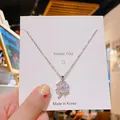 Élégant collier trèfle en titane argenté avec cristaux étincelants sur carte cadeau - Trèfle en Zircone