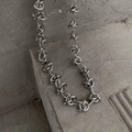 Detail of silver interlocking knot chain necklace with industrial style metal finish - Necklace / Silver