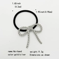 Detailed view of the gold bow hairband showing its metal texture and dimension specs - Twisted Bow / Silver