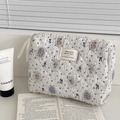Quilted bear pattern makeup bag with blue floral print and zipper closure on white desk - Badge Bear - Clutch Pouch