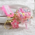 Pink Sakura cherry blossom liquid sand lollipop keychain with colorful pompom filling - Pink