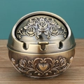 Nahaufnahme eines bronzenen Kugel-Aschenbechers mit Rosenreliefs und drei Zigarettenschlitzen - Bronze Herz Kleine Rose