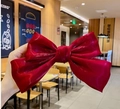 Large red satin bow hair clip held by hand, elegant hair accessory for women - Red Iridescent Bow Clip