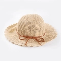 Detailed weave texture of beige summer straw hat with wavy brim and brown ribbon - Adult M (56-58cm) / Beige