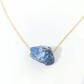 Minimalist golden necklace featuring a large irregular natural blue raw stone pendant - Lapis Lazuli