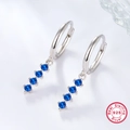 Close-up of 925 sterling silver hoop earrings with four prong-set blue zircons - Silver/Blue
