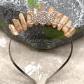 Macro shot of orange crystal crown with hand-wrapped wire and silver moon goddess emblem - Brown Crystal with Triple Moon