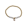 Detail of beaded bracelet with gold metal beads, white pearls and a colorful crystal Q charm - Letter G
