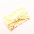Close-up of baby yellow nylon headband featuring a large bow and cable knit texture - Creamy Yellow