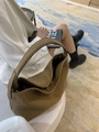 Detailed close-up of olive green woven leather tote bag with smooth handles and gold hardware - Khaki