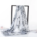 Elegant white silk scarf with black paisley floral patterns draped on minimalist black frame - 90x90cm / Paisley Grey White