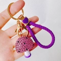Close-up of purple rhinestone mushroom keychain with gold clasp and braided strap - Mushroom + Heart Strap / Purple