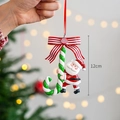 Hand holding 12cm Santa Claus hanging ornament with red bow and green candy cane - Santa Claus