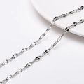 Macro detail of silver-colored twisted link chain made of high-gloss polished titanium steel - Style 12 Flat Oval Chain (FLB074) / 1 Meter