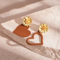 Detail of asymmetrical daisy earrings with matte brown heart pendants on stone - Coffee Asymmetric Daisy Heart (Silver Pin)