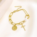 Detail of baroque pearl gold bracelet with stainless steel cross and engraved charms - Cross Pearl Style