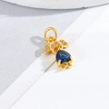 Macro shot of gold boy-girl pendant featuring a blue heart gemstone and white diamonds - Little Girl - Blue Heart