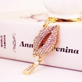 Sparkling red lips keychain with small lipstick charm on gold-tone metal base - White