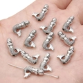 Macro view of silver mermaid metal pendants held in hand for jewelry DIY scale reference - Mermaid / 9x13mm
